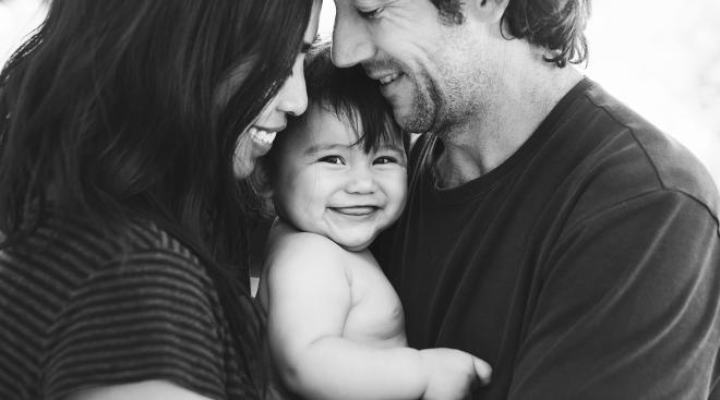 Cute baby smiling between two happy parents