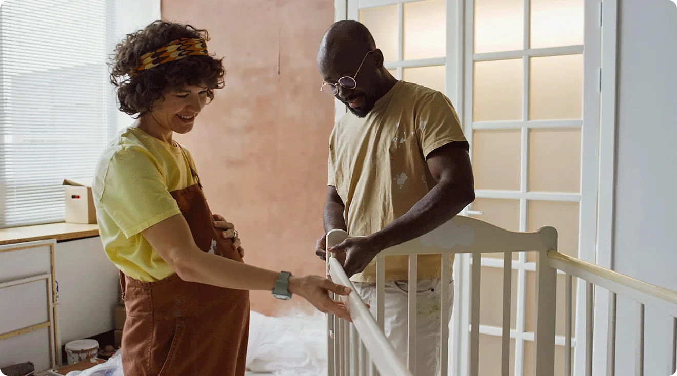 pregnant couple building a baby crib in nursery