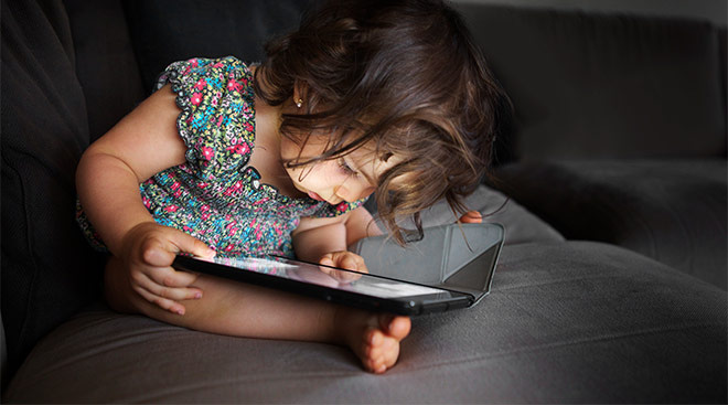 toddler closely looking at screen