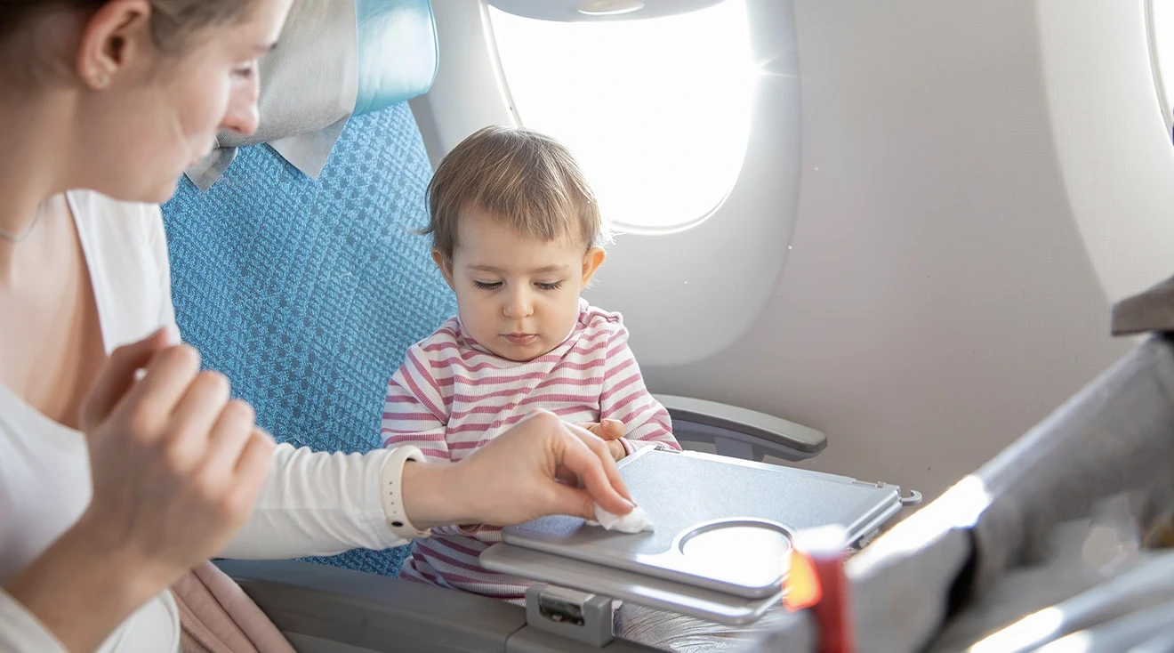 mother cleaning up after toddler on airplane