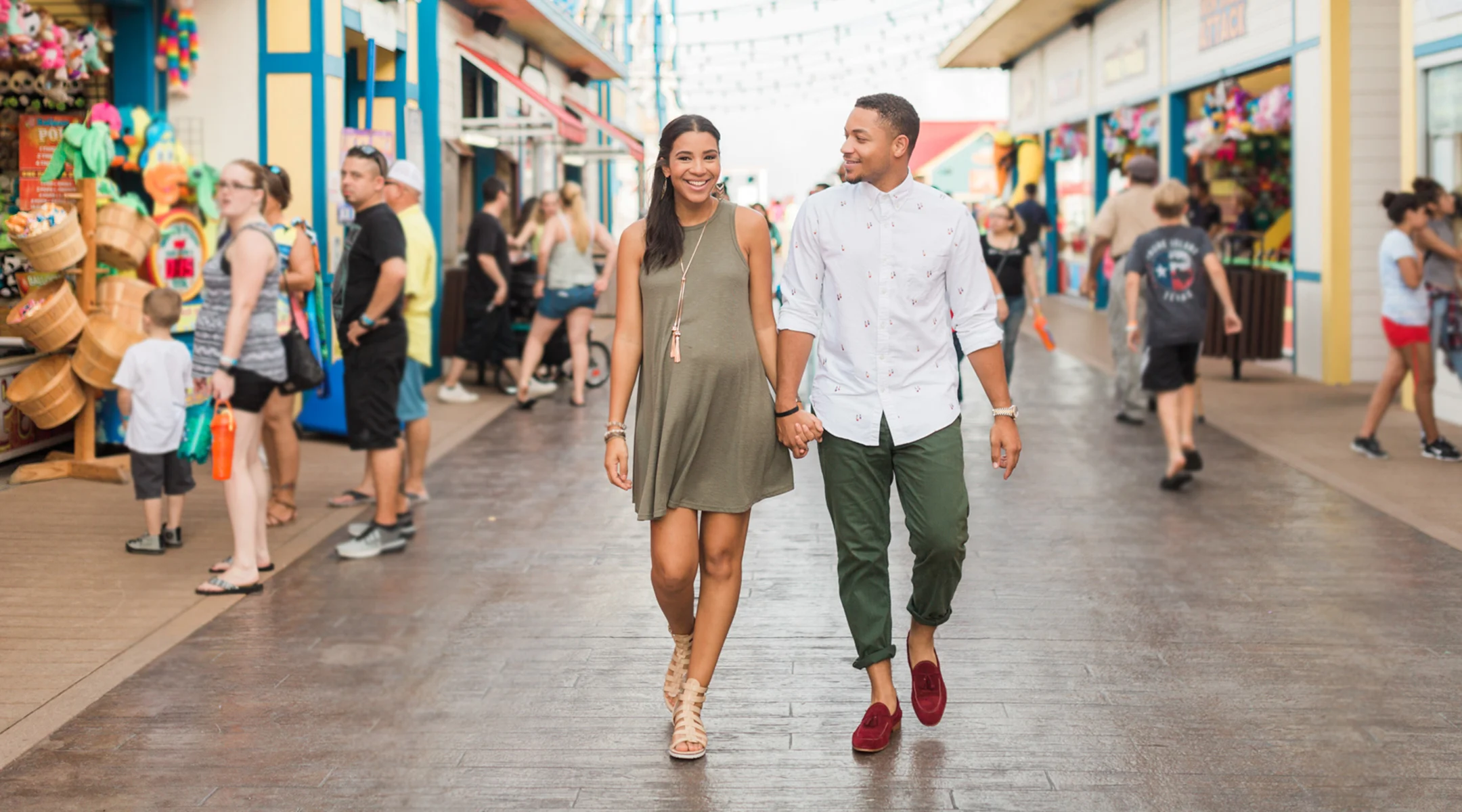 pregnant woman with husband babymoon beach boardwalk