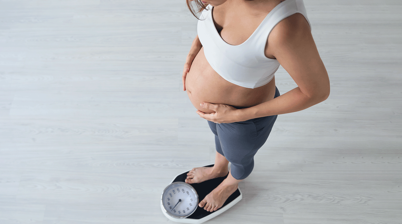 pregnant woman standing on scale