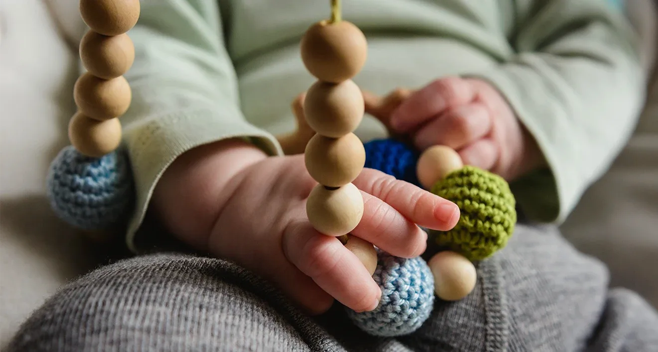 Teething necklaces held by baby-hero