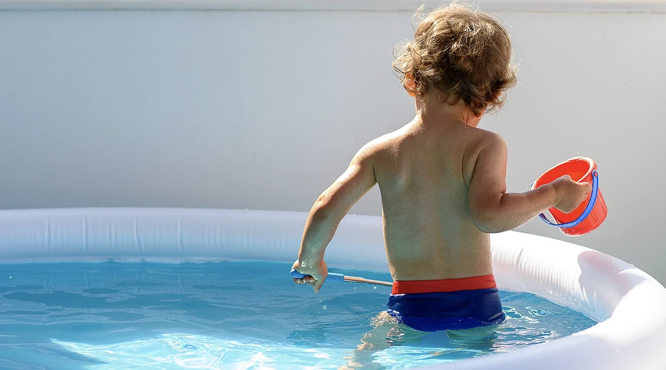 toddler in kiddie pool on summer day