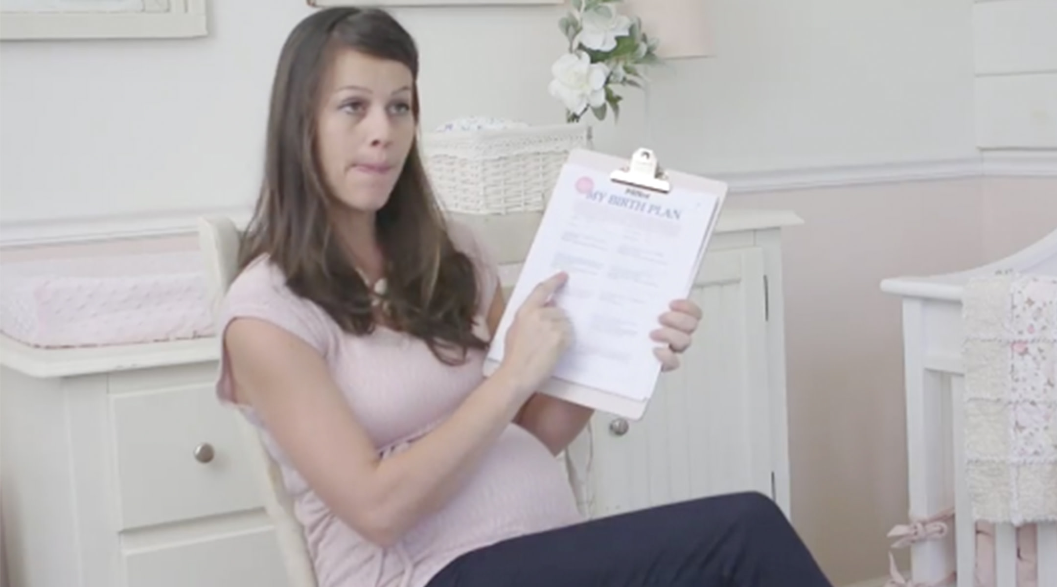 Pregnant woman holding up a copy of her birth plan
