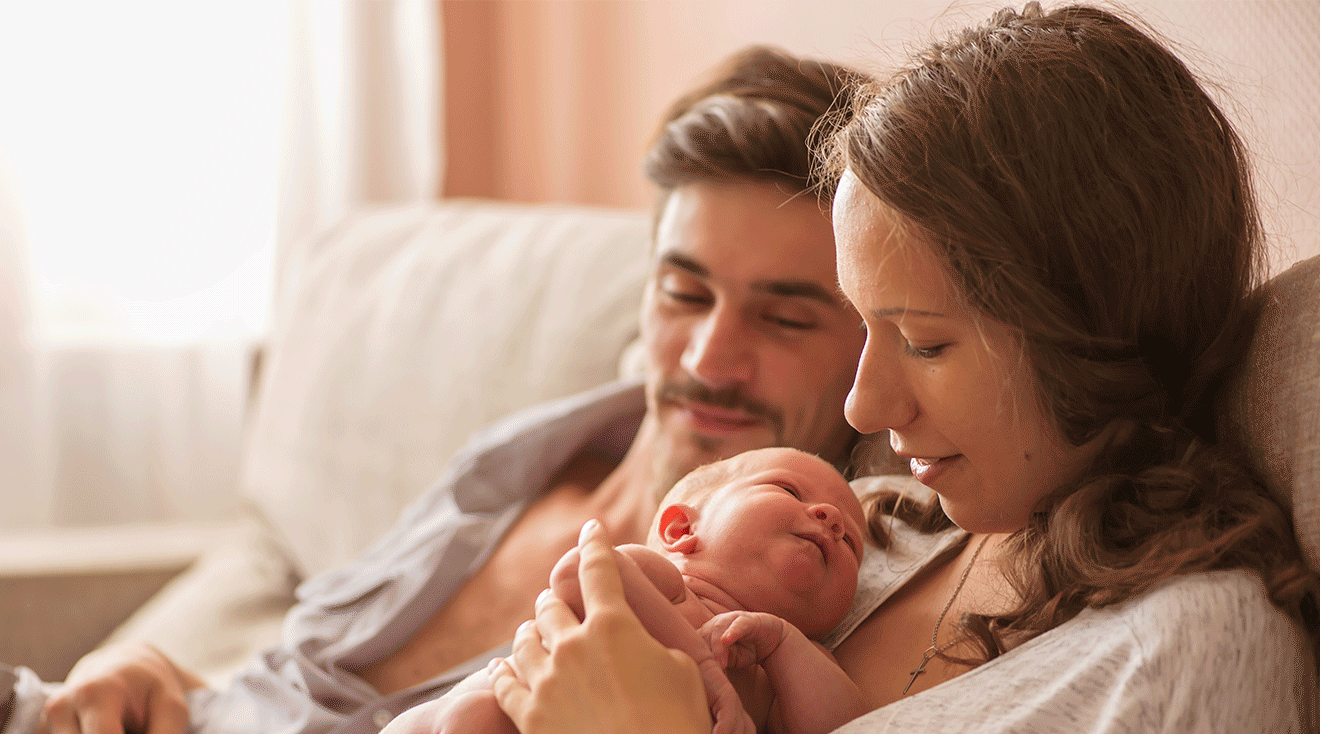 parents holding newborn baby at home