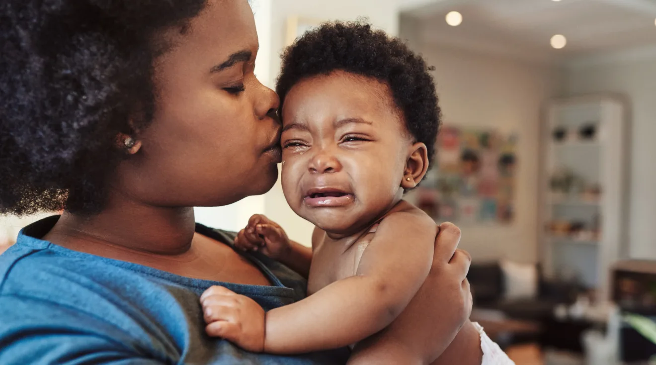 mom kissing crying baby