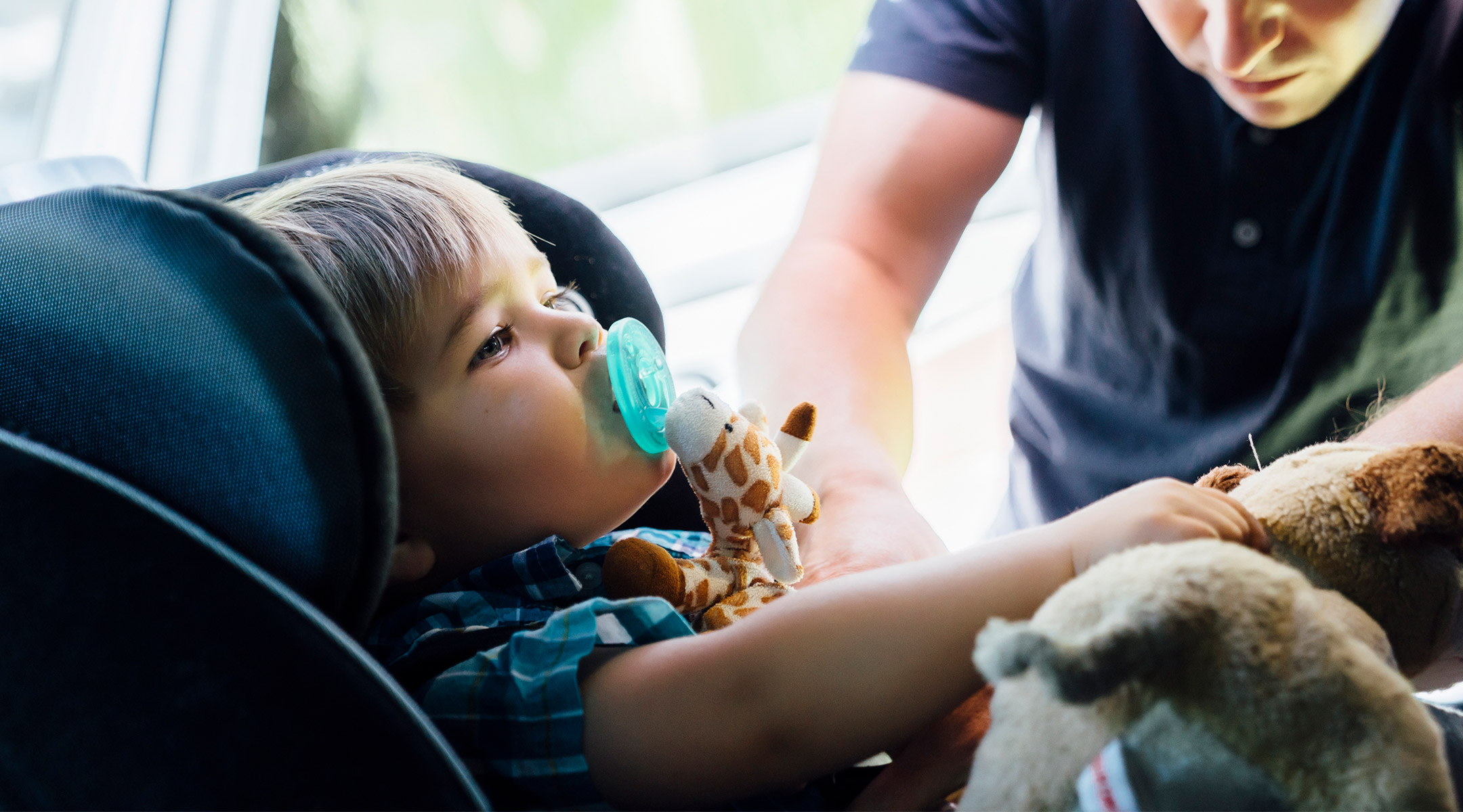 dad putting his child into car seat