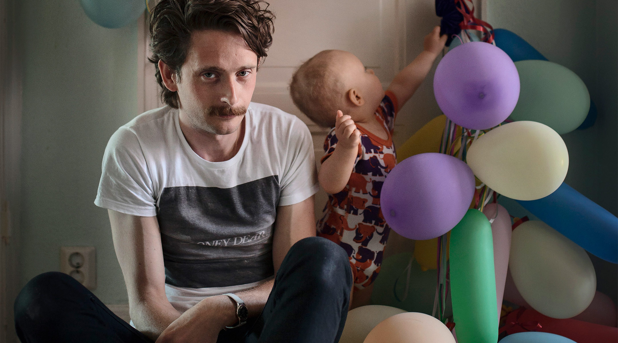 swedish dad on paternity leave, with baby playing with balloons 