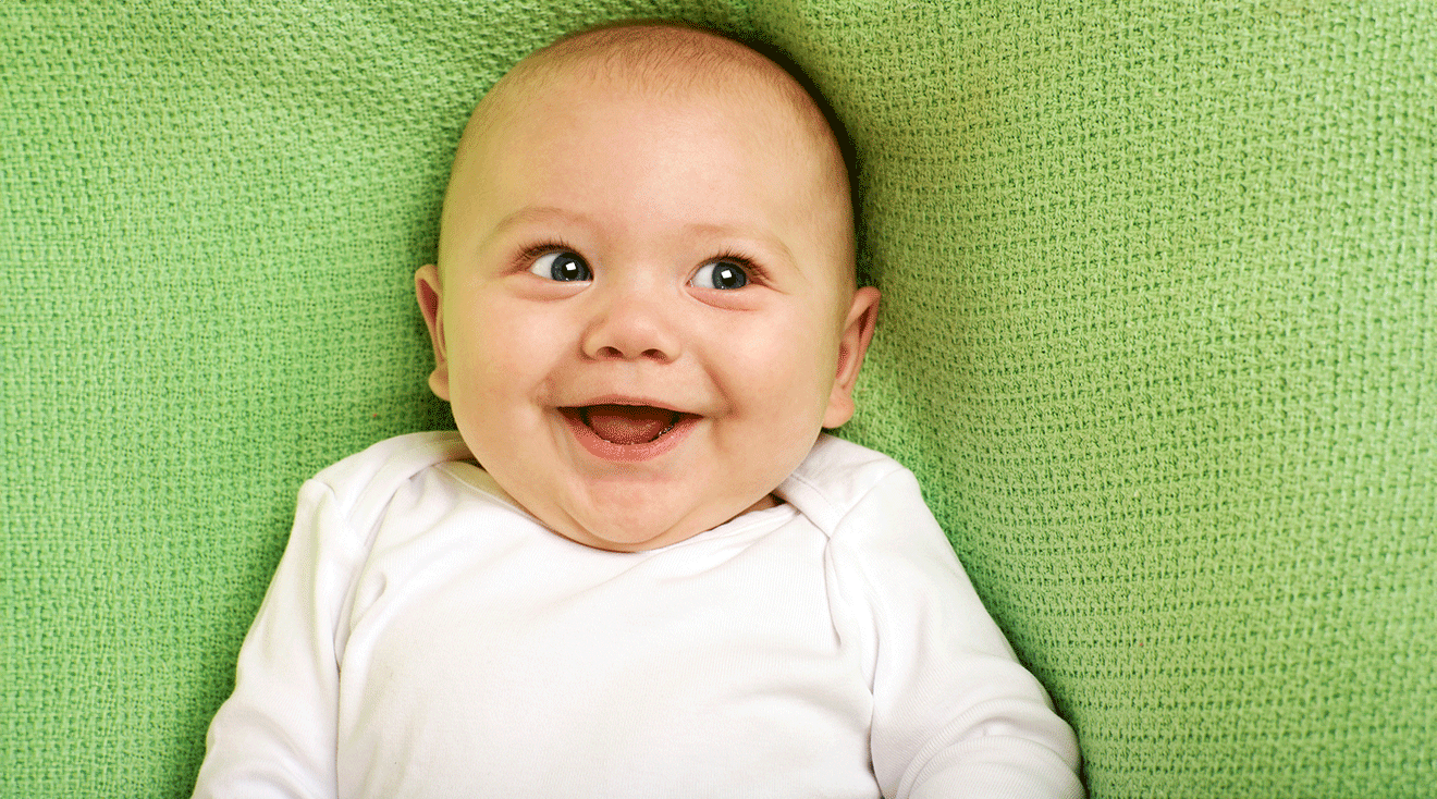 smiling baby with bright green background