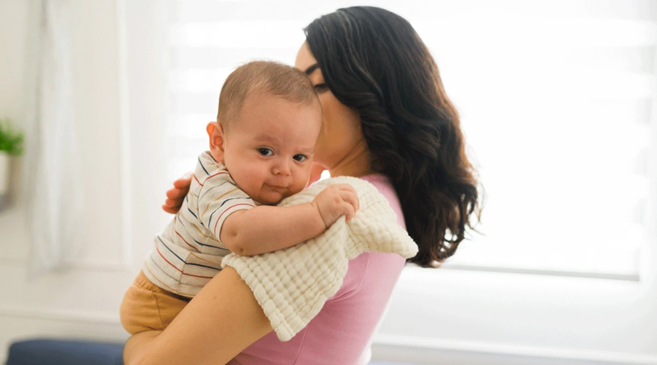 mother burping baby with burp cloth