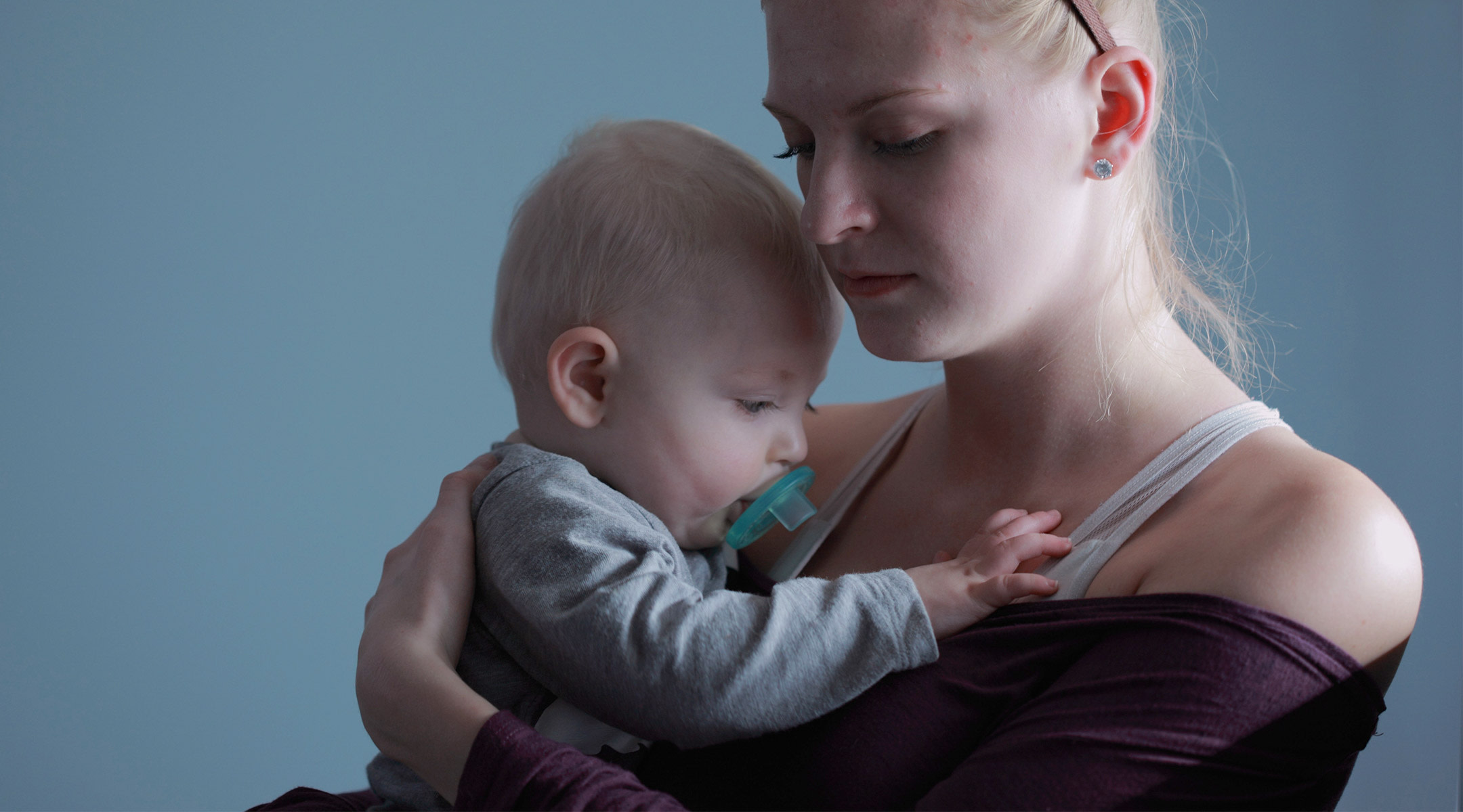 mom with postpartum depression holds baby