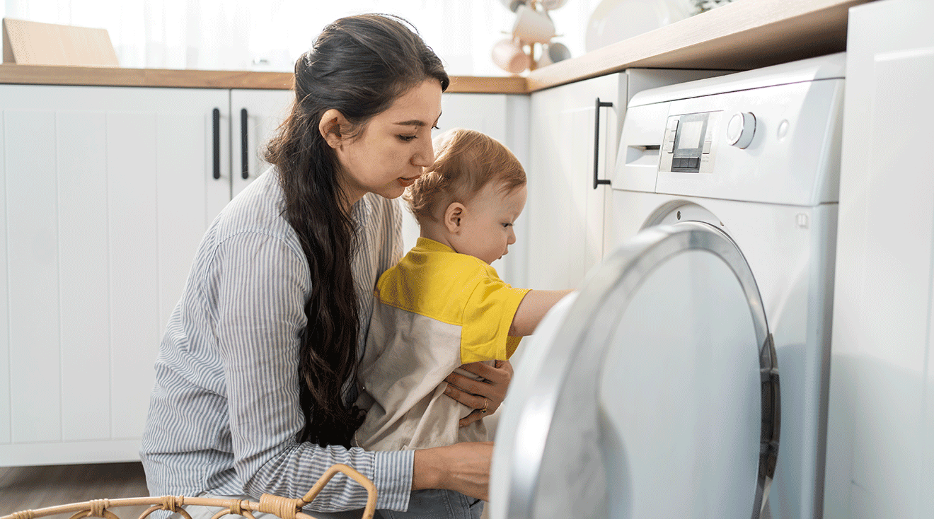 babysitter doing laundry with toddler