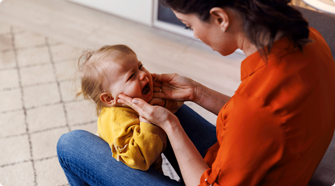 mom comforting crying toddler; terrible twos