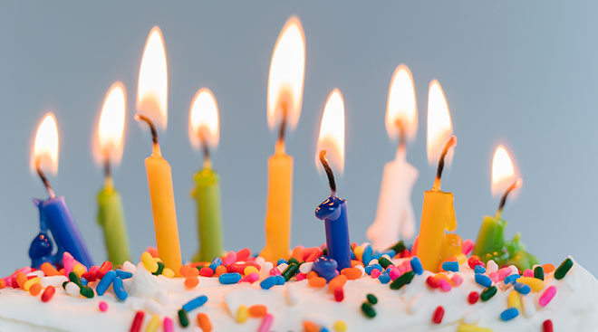 close up of lit candles on a birthday cake
