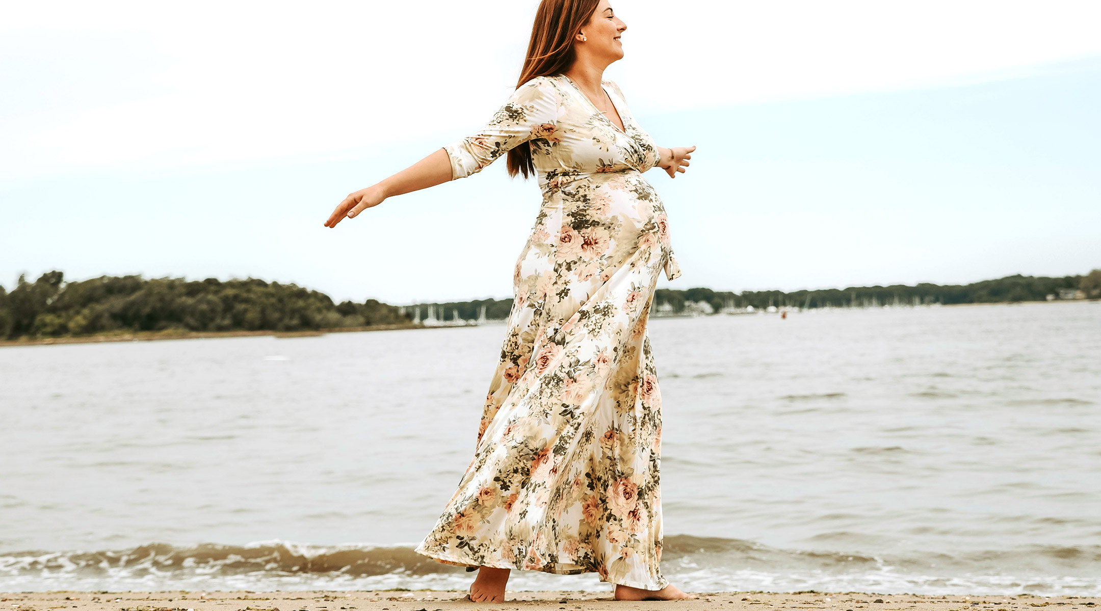 pregnant mom to be happily dancing on the beach