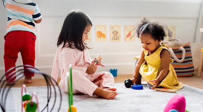 two toddlers playing with toys at daycare