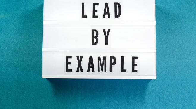 letter board that says lead by example