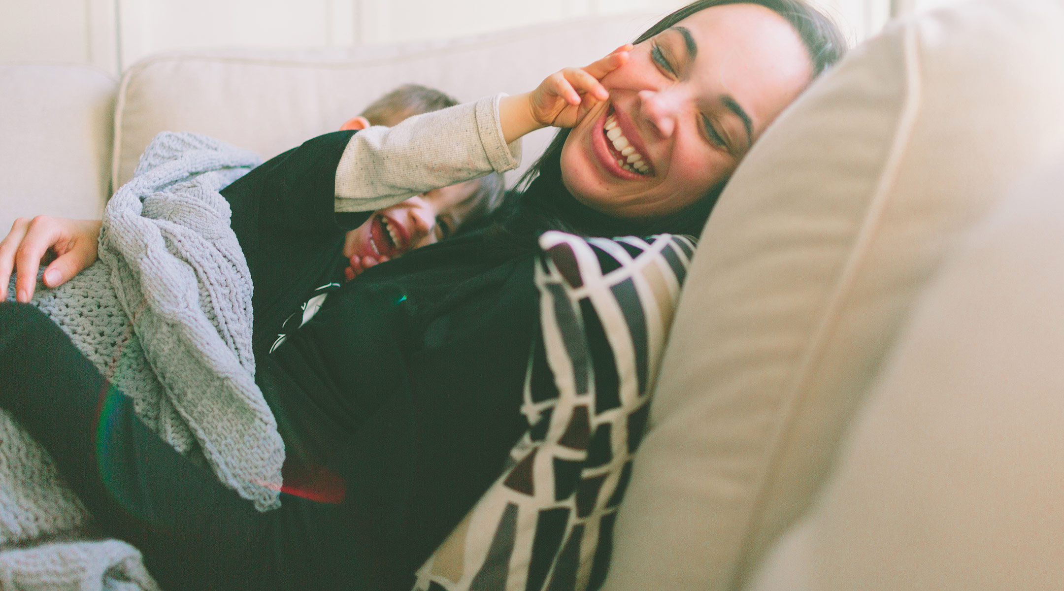 mom and son laughing together on the couch