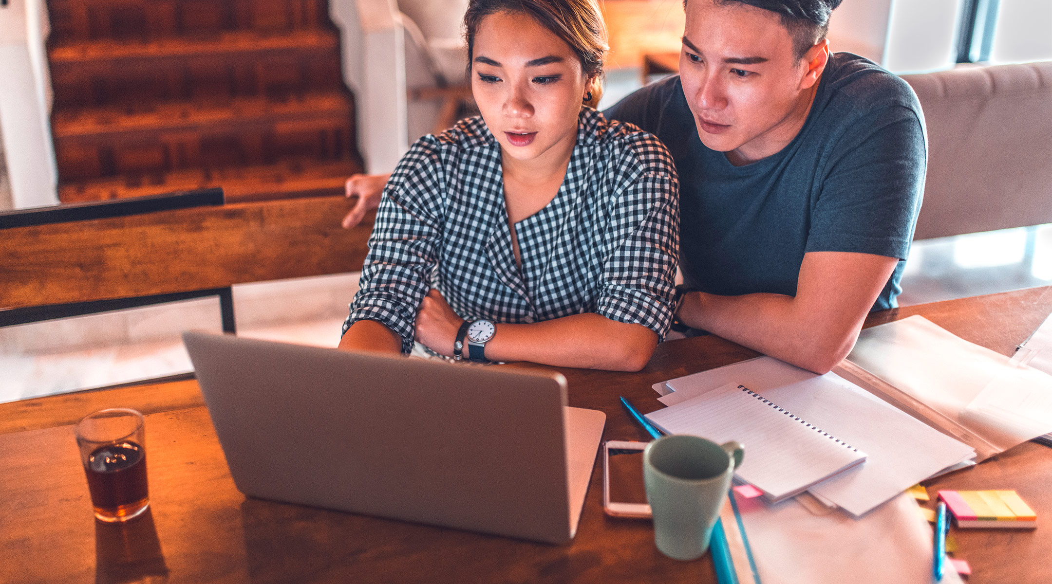 couple with blank faces looking at computer together