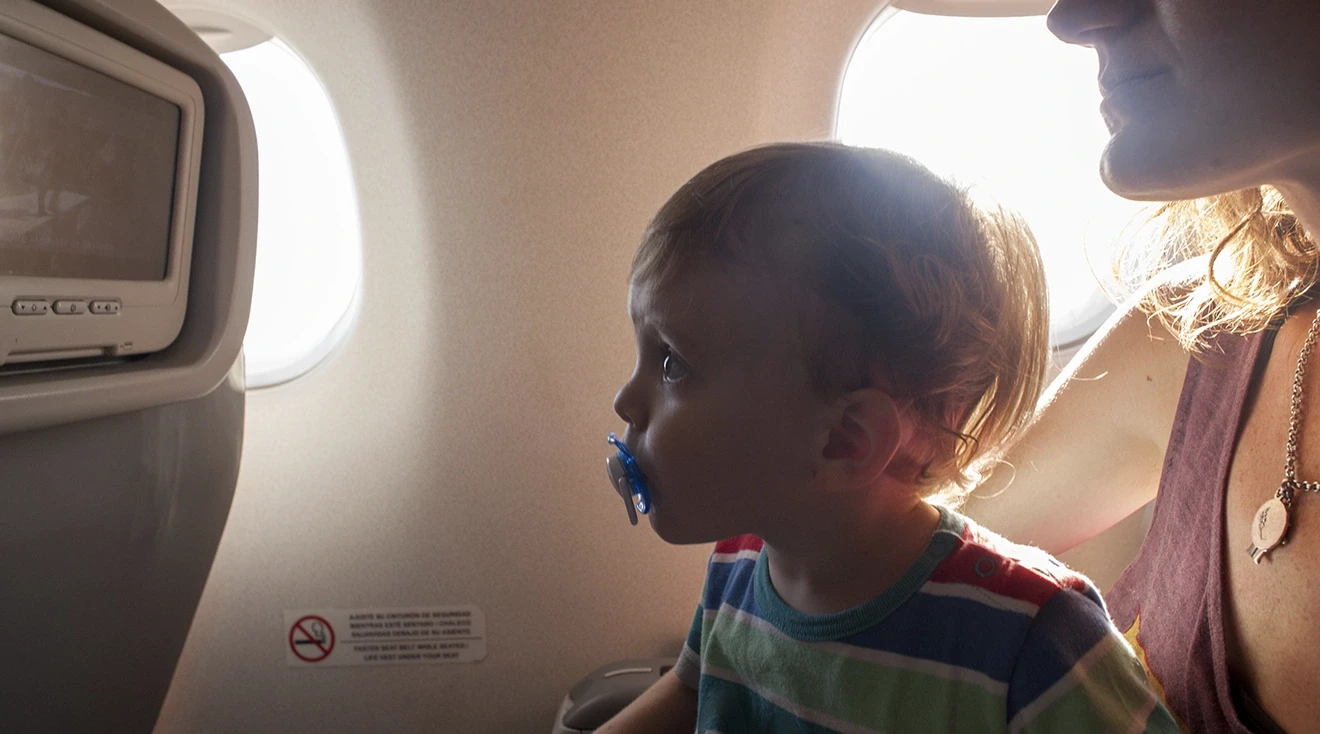 toddler and mom on airplane watching TV