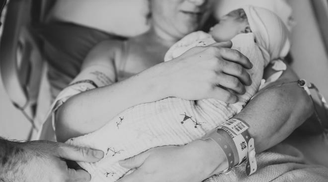 mom who used epidural, holds newborn baby in her arms 