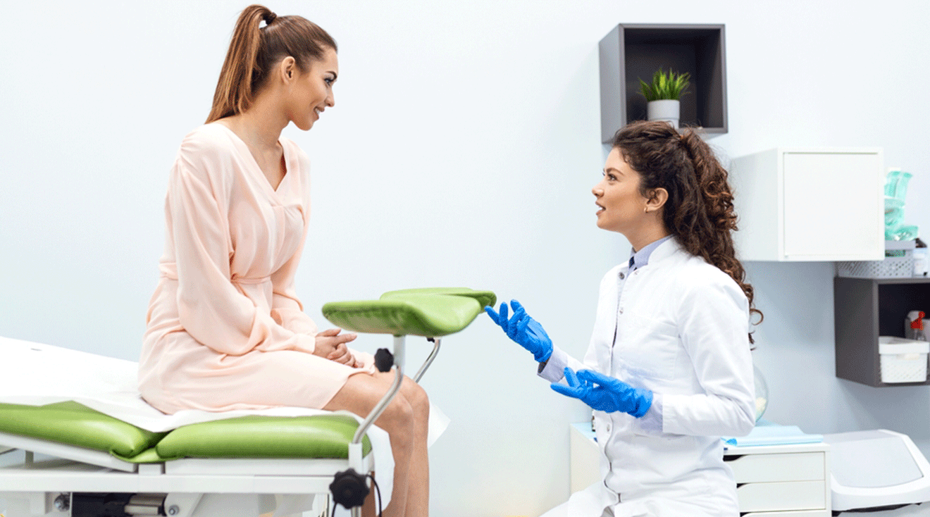 woman talking to gynecologist in exam room