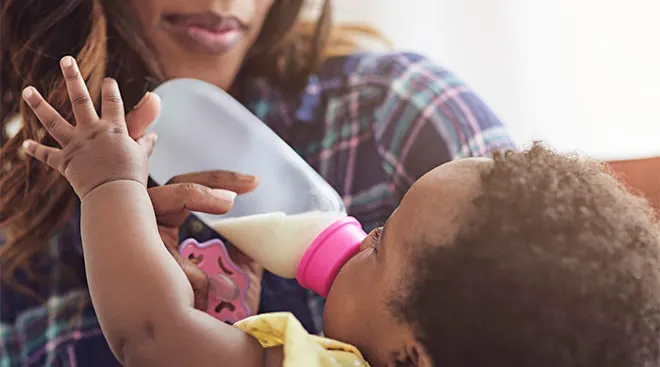 mom feeding baby formula from bottle