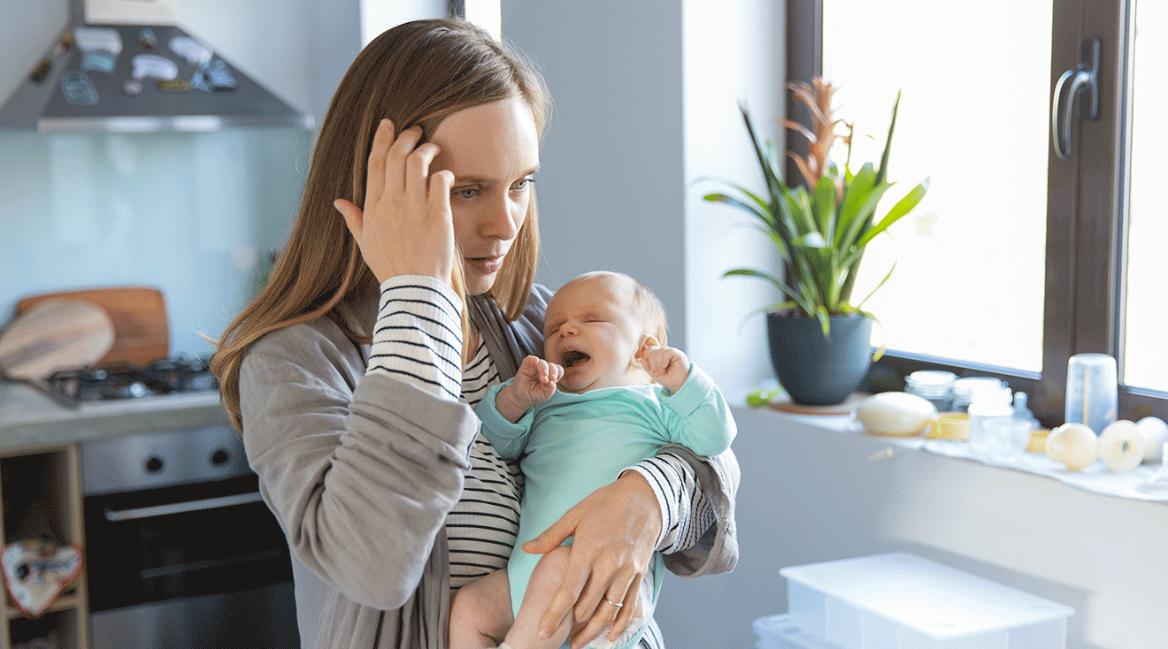 concerned and tired mother holding newborn baby at home