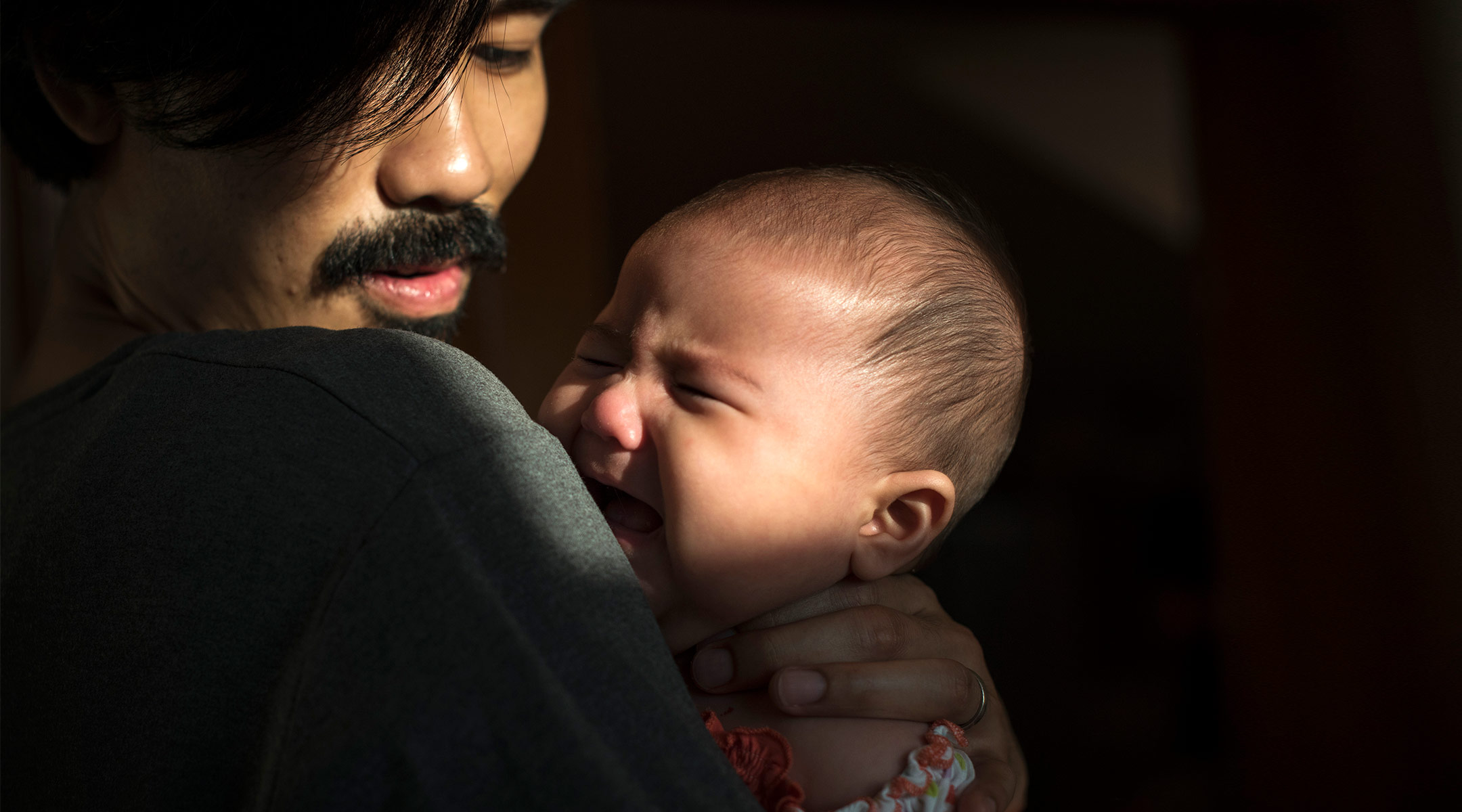 dad holding crying baby