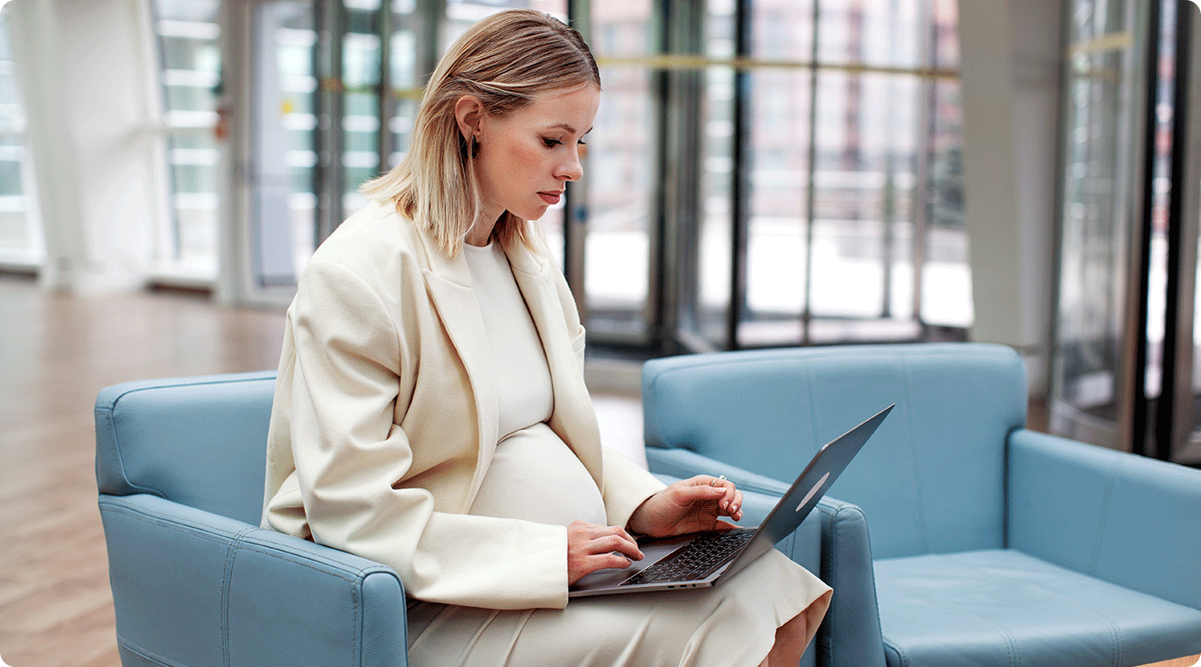 corporate pregnant woman working on laptop at work