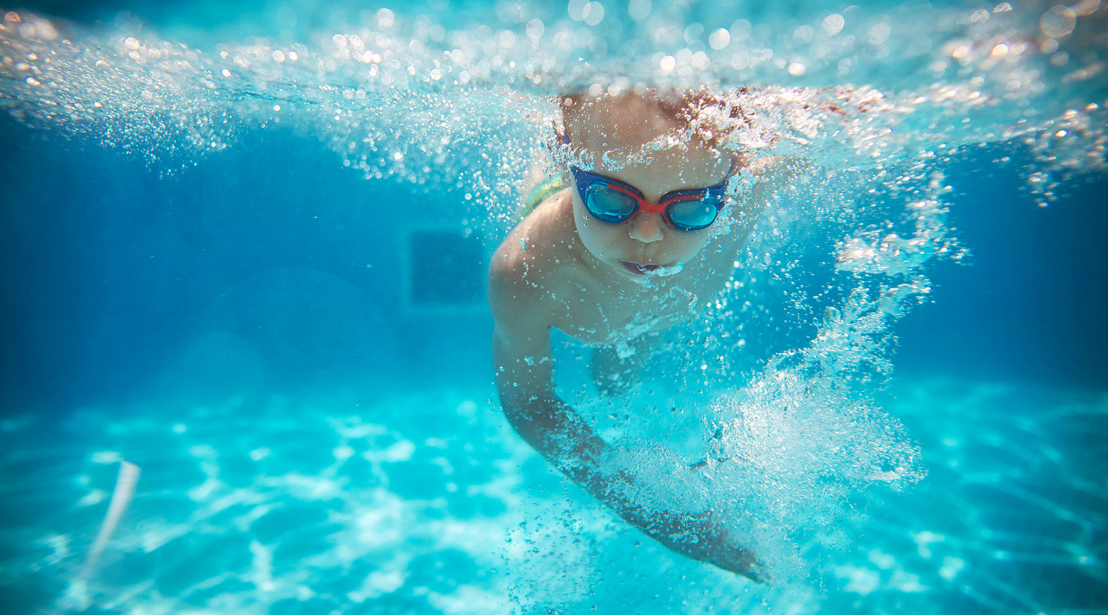 young child swimming in pool underwater