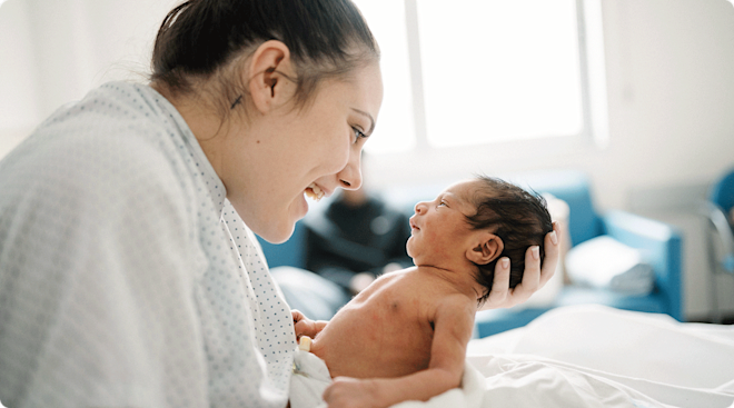 mom holding her newborn baby in hospital bed