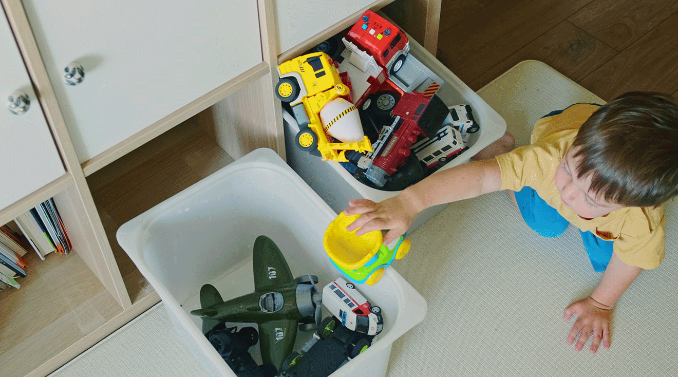 toddler cleaning up toys
