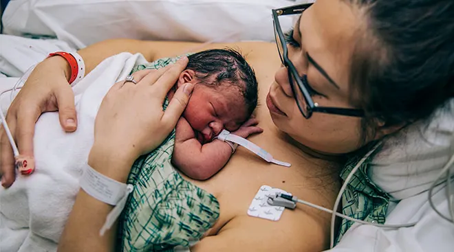 newborn and new mom doing skin to skin contact after birth