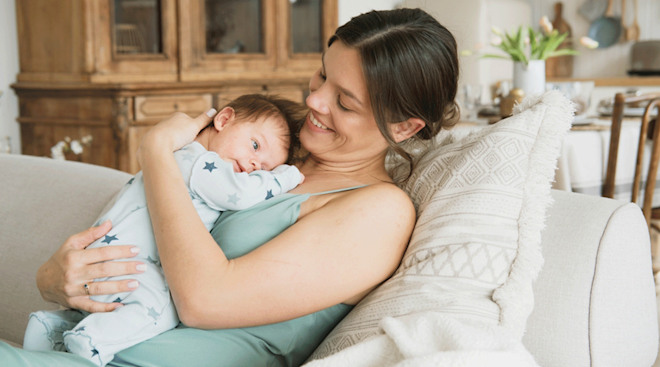 mom cuddling newborn baby at home
