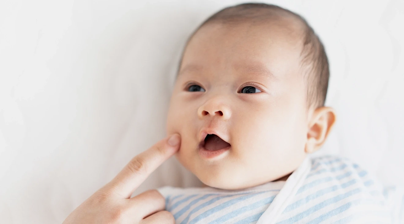 mother testing rooting reflex by touching baby's cheek 