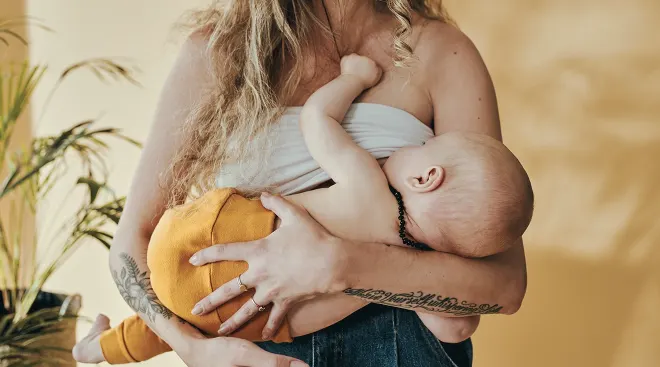 mother with tattoos breastfeeding baby