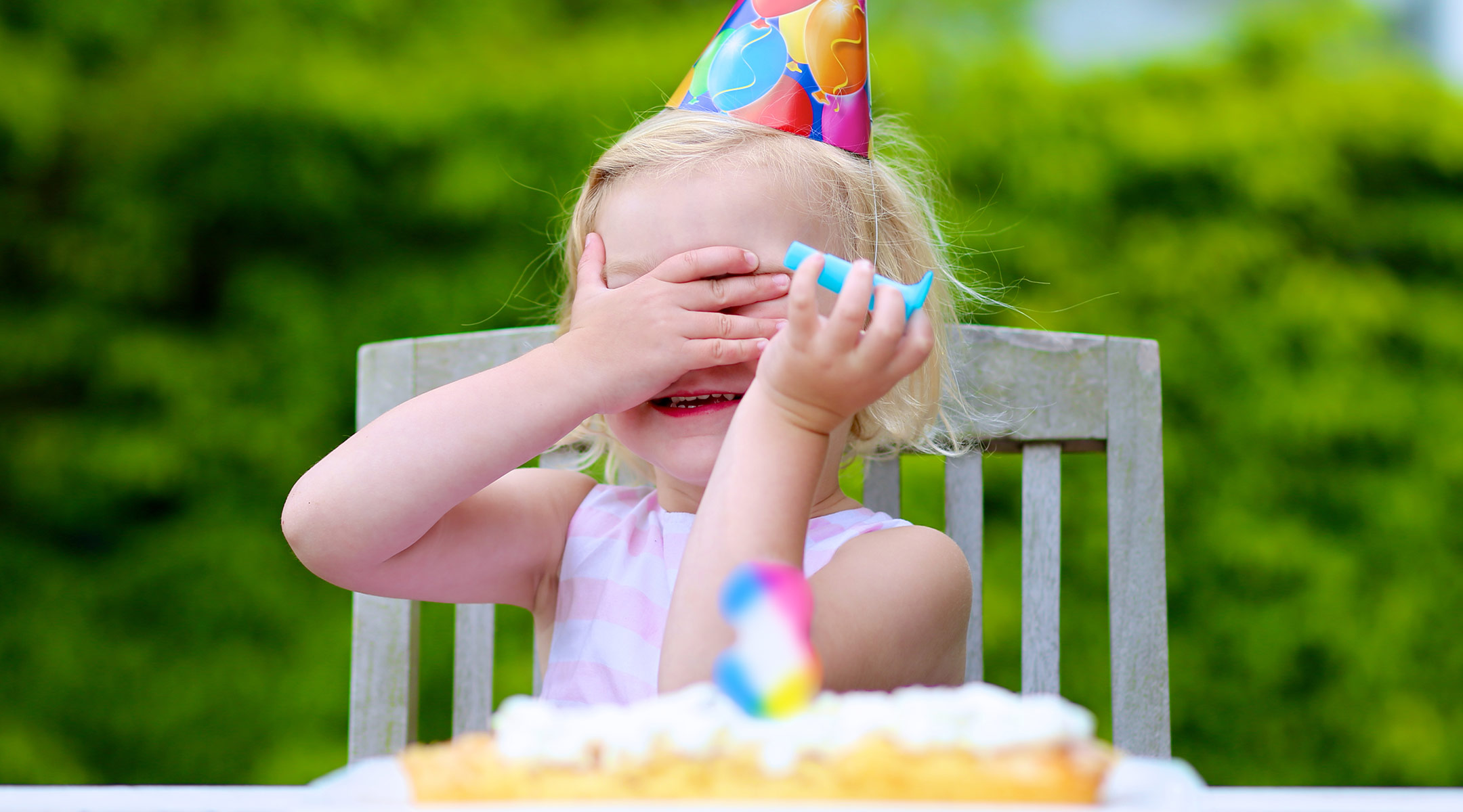 toddler birthday girl covering her face with her hands