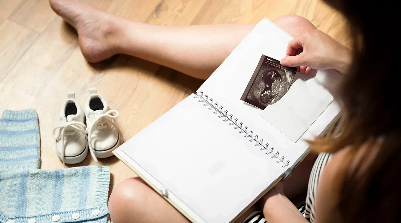 mother holding a book with baby photos