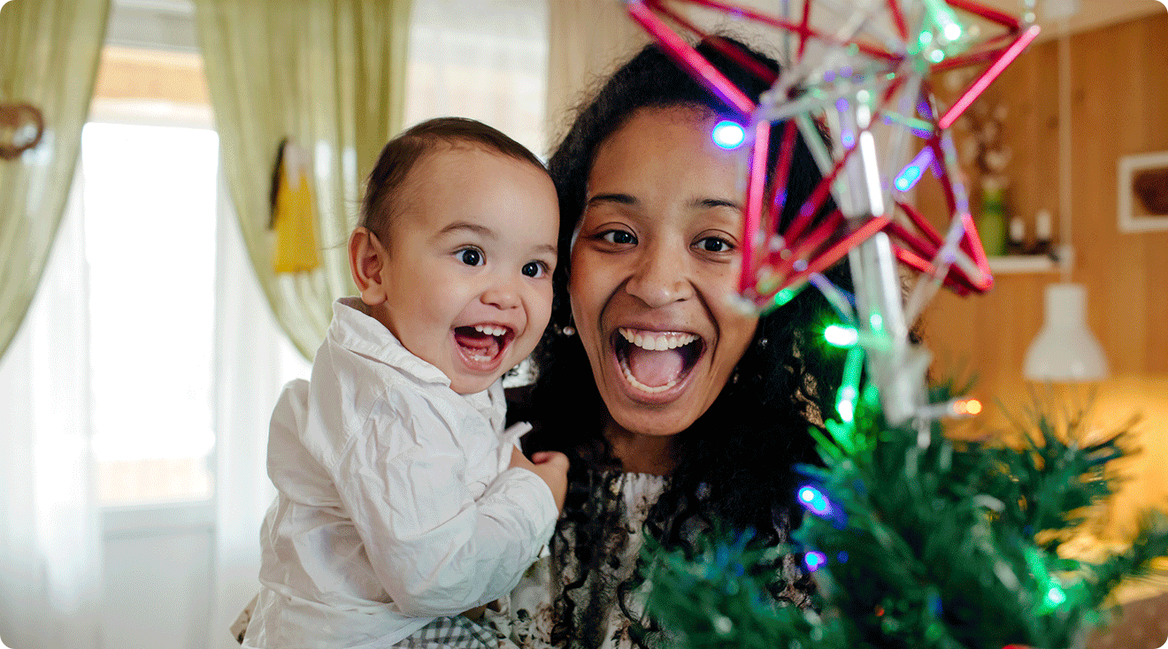 mom and baby smiling at christmas tree