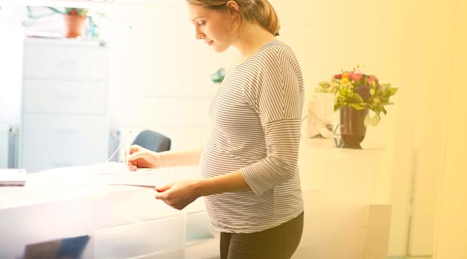 pregnant woman filling out forms at doctor's office