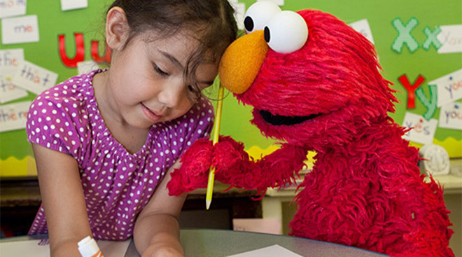 sesame street's elmo plays with little girl