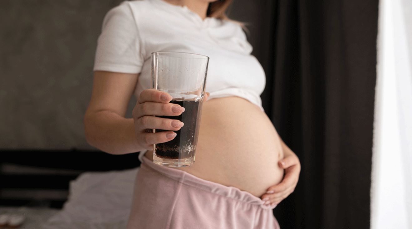 pregnant woman holding a glass of soda