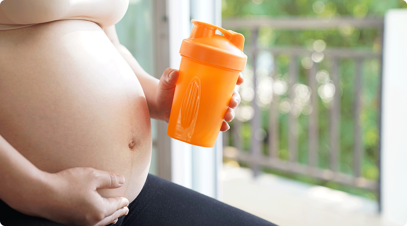 pregnant woman holding workout drink shake bottle