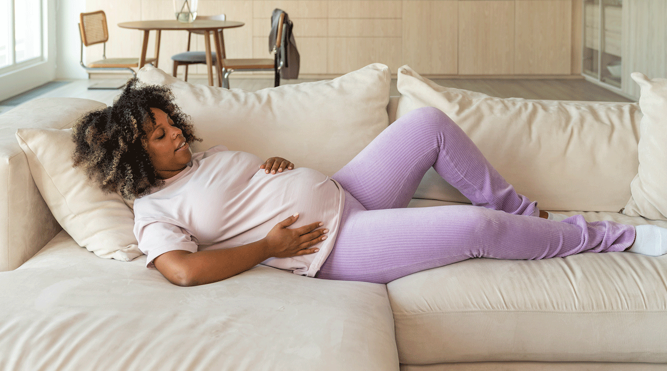 pregnant woman resting on couch at home