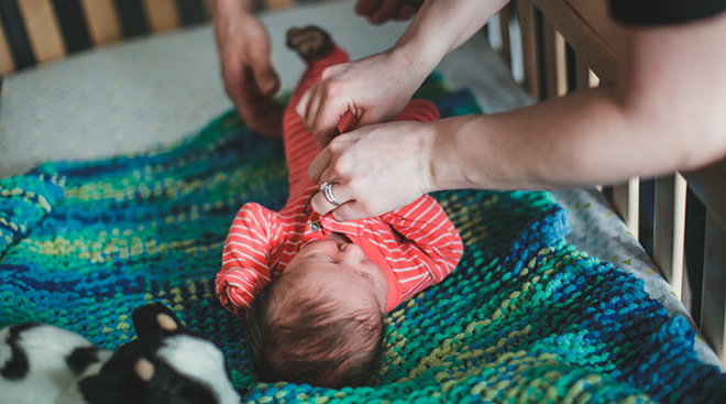 parents dressing baby