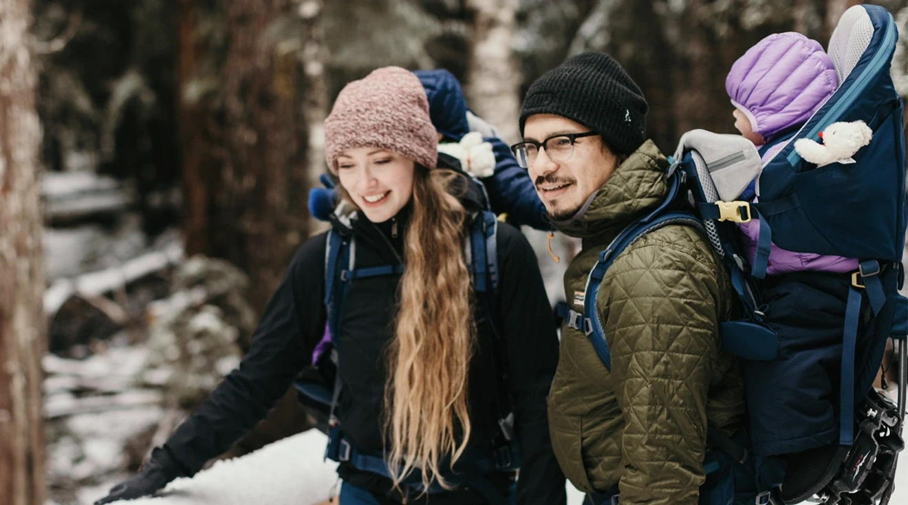 family hiking during the winter with baby backpack carriers