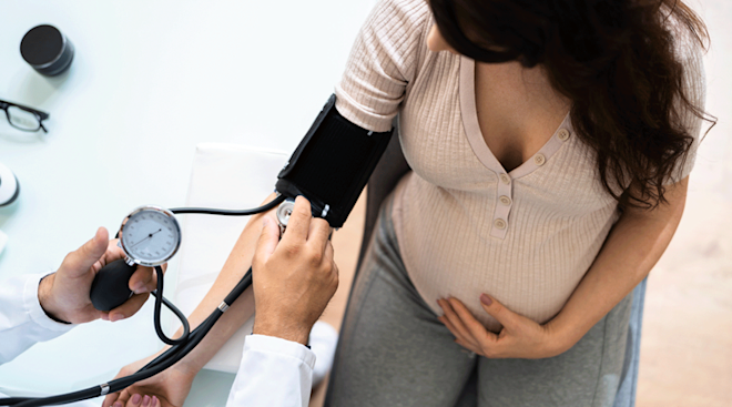 doctor measuring pregnant woman's blood pressure