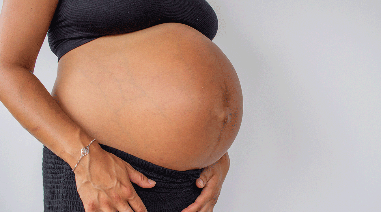 close up of pregnant woman's belly and belly button